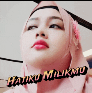 a woman wearing a pink hijab with the words hatiku milikmu written on the bottom
