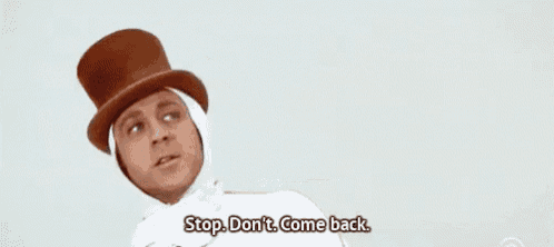 a man wearing a top hat and a white cape is talking .