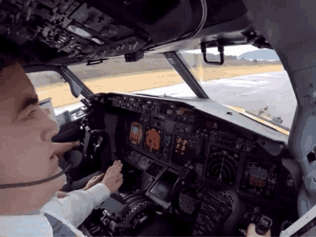 a man in a cockpit of an airplane with a headset