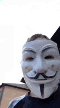 a man wearing a white anonymous mask with a black mustache