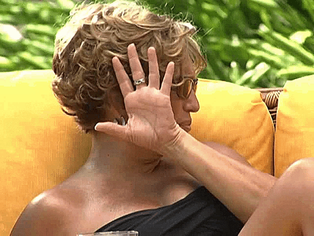 a woman covering her face with her hand wearing a ring