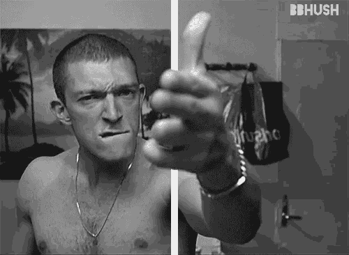 a black and white photo of a shirtless man giving a thumbs up