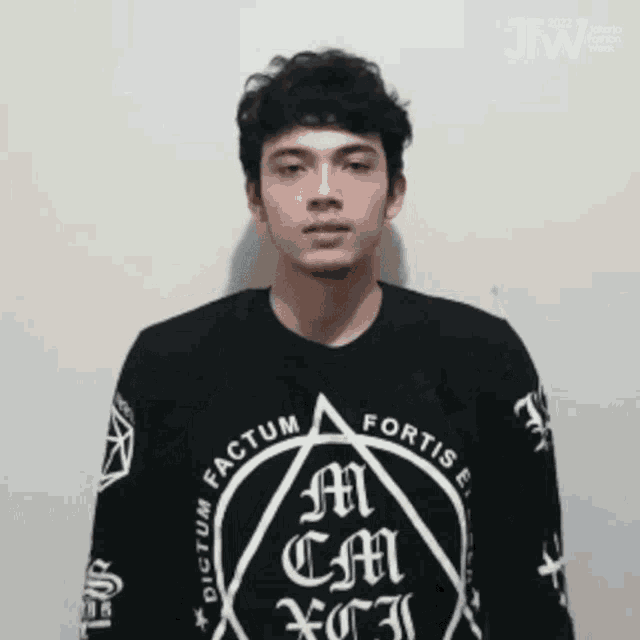 a young man wearing a black shirt that says " factum " on it