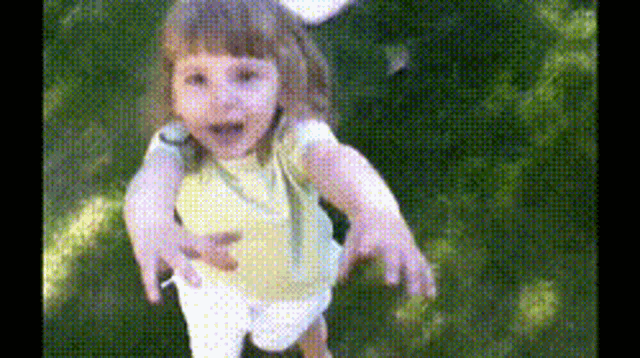 a little girl in a yellow shirt and white shorts