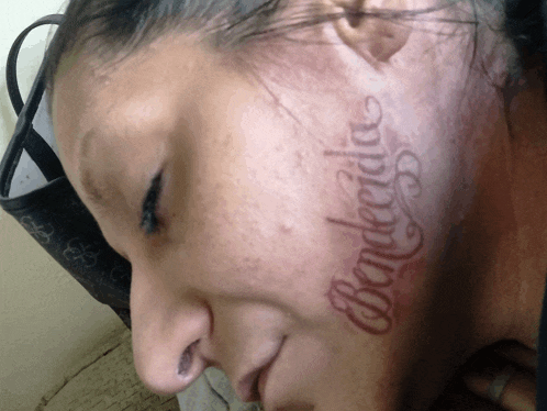 a woman with a tattoo on her face that says banderdia