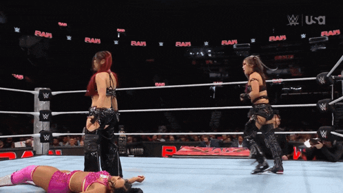 two women in a wrestling ring with the word raw on the wall