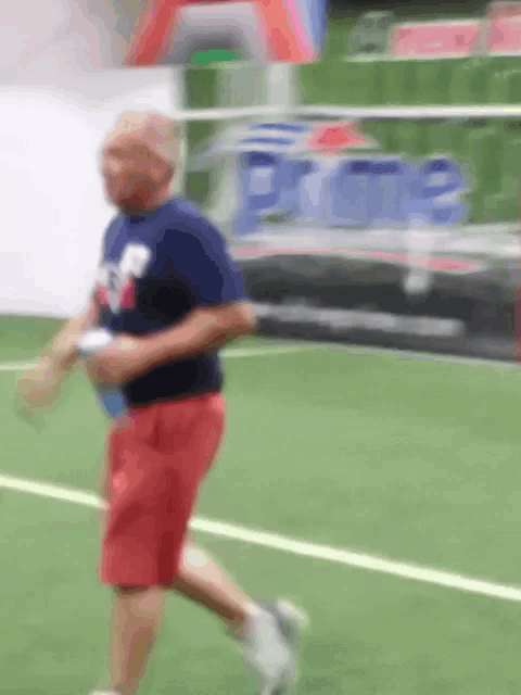 a man in red shorts is running on a tennis court