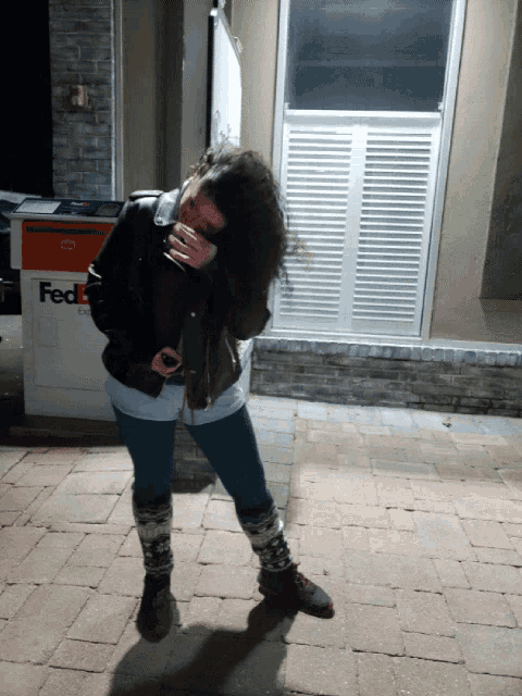 a woman standing in front of a fedex container
