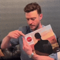 a man is reading a book with a red circle on the cover
