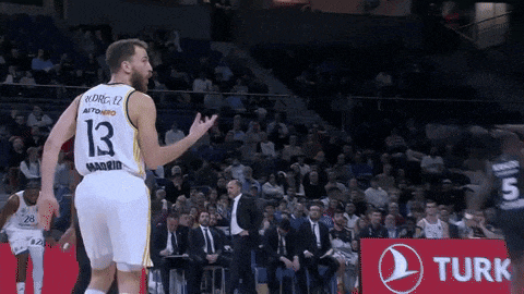 a basketball player wearing a number 13 jersey stands in front of a turk advertisement