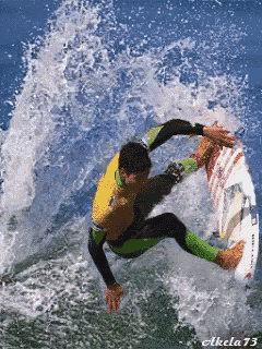a man in a yellow shirt is riding a wave on a surfboard with the number 73 on the bottom