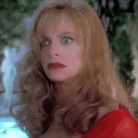a woman with blonde hair and red lipstick is making a surprised face