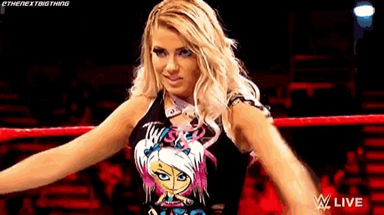 a woman in a wrestling ring is wearing a t-shirt with a cartoon girl on it .