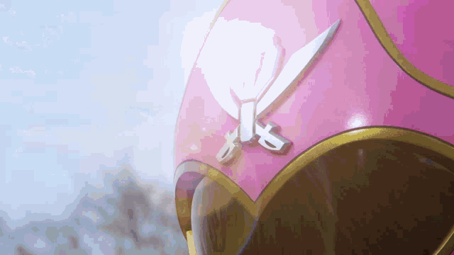 a close up of a pink helmet with a pair of scissors on it