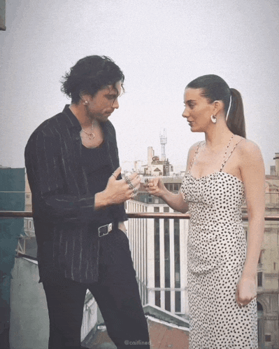 a woman in a polka dot dress stands next to a man