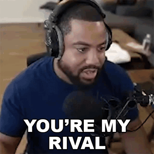 a man wearing headphones is talking into a microphone and saying `` you 're my rival ''