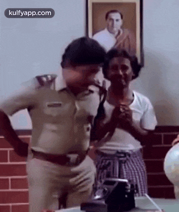 a police officer is dancing with a man in a room in front of a picture of a man .
