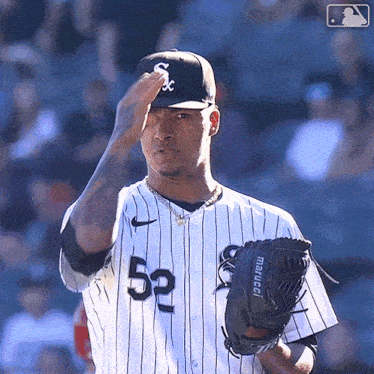 a baseball player wearing a white and black uniform with the number 52 on it