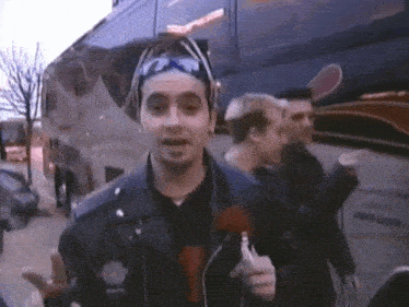 a man wearing sunglasses and a headband stands in front of a van that says ' a & a ' on it