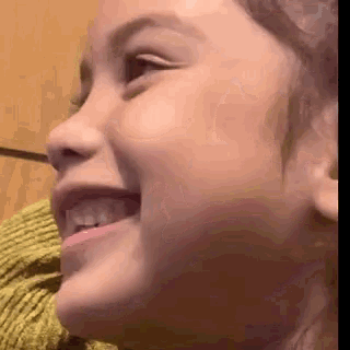 a close up of a little girl 's face smiling