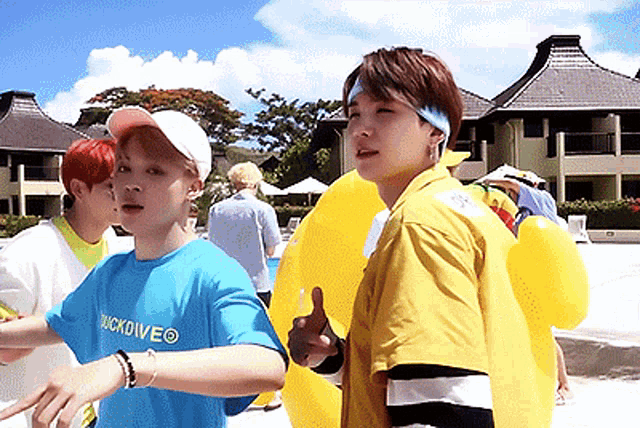 a boy wearing a blue shirt that says quickdiveo is standing next to a boy wearing a yellow jacket
