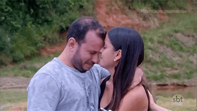 a man and woman are hugging each other and kissing .