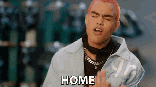 a young man with red hair is wearing a blue jacket that says home on it