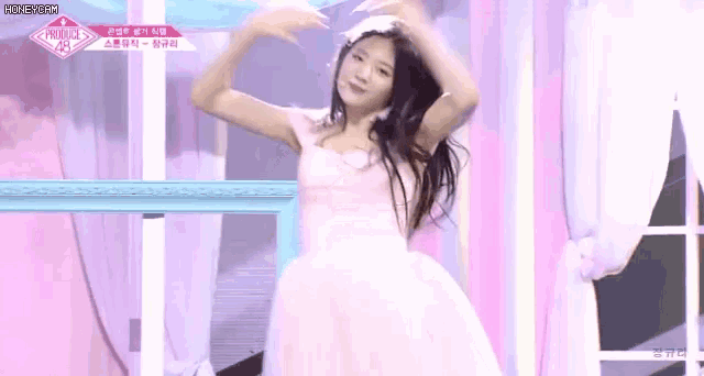 a woman in a pink dress is dancing on stage .
