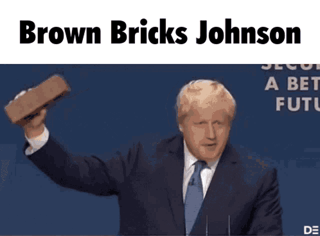 a man in a suit and tie is holding a brown brick in his right hand