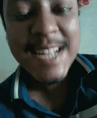 a man with a beard and mustache is smiling with his eyes closed and his mouth open .