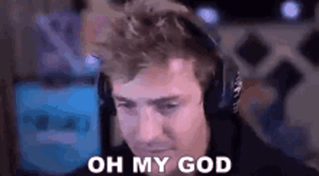 a man wearing headphones is saying `` oh my god '' while looking at a computer screen .