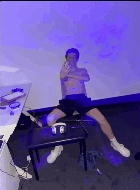 a man without a shirt is sitting on a piano bench