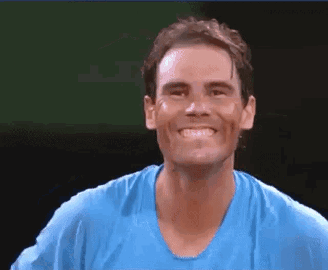 a man wearing a blue shirt is smiling while someone pulls his shirt up .