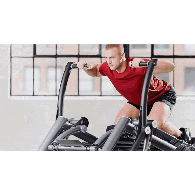 a man in a red shirt is riding a machine