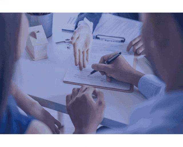 a man is signing a document with a pen