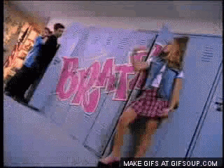 a girl is sitting on a locker with the word brat painted on the wall