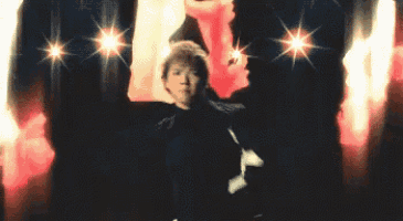 a man and woman are dancing on a stage in front of a crowd .
