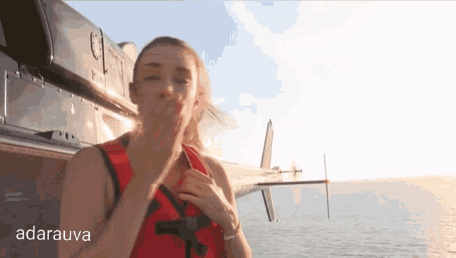 a woman blows a kiss in front of a helicopter and the word adarava is visible