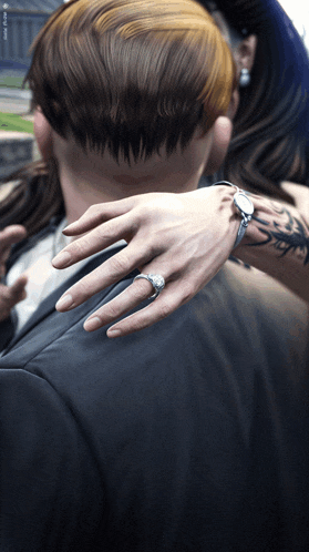 a woman wearing a ring on her finger holds a man 's arm
