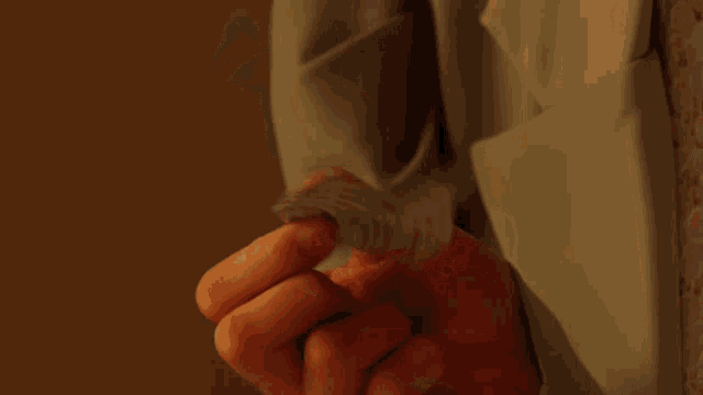 a close up of a woman 's fist with a light blue jacket on