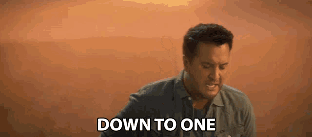 a man says down to one in front of a sunset