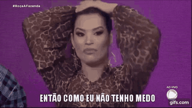 a woman in a leopard print shirt is holding her hair in a ponytail and says então como eu não tenho medo