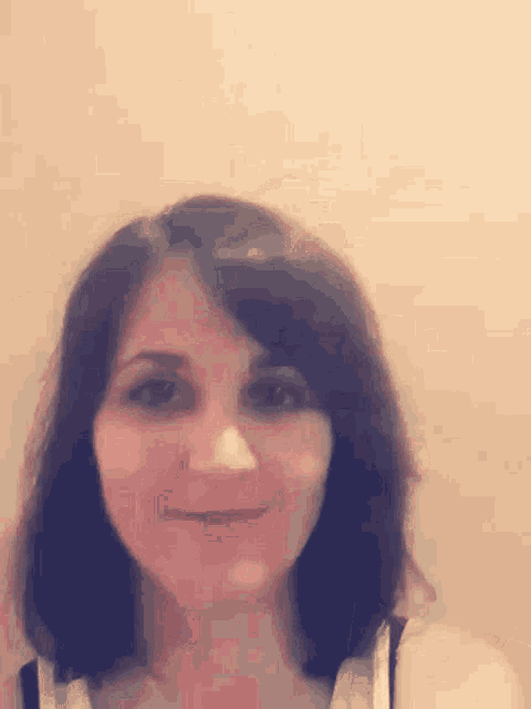a close up of a woman 's face against a wall