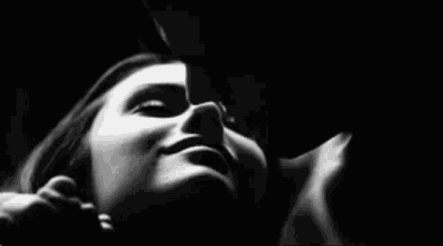 a black and white photo of a man kissing a woman 's forehead .