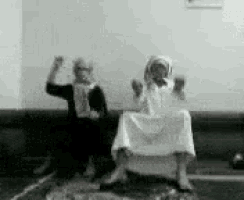 two people are standing next to each other on a couch in a room .