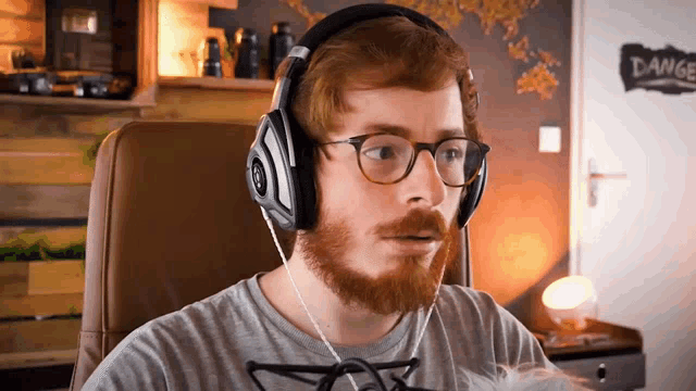 a man with a beard wearing headphones looks surprised