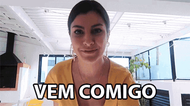 a woman in a yellow shirt says " vem comigo " in black letters