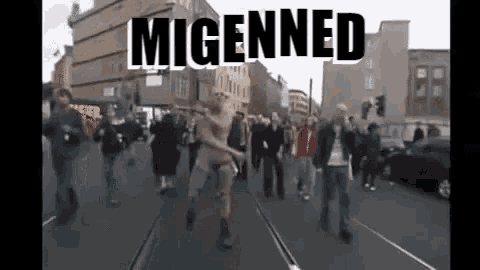 a group of people are walking down a street with the word migenned on the bottom