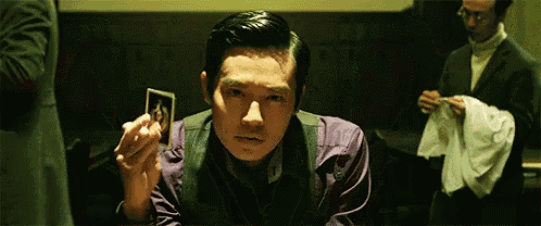 a man in a purple shirt is holding a picture of a woman in his hand .