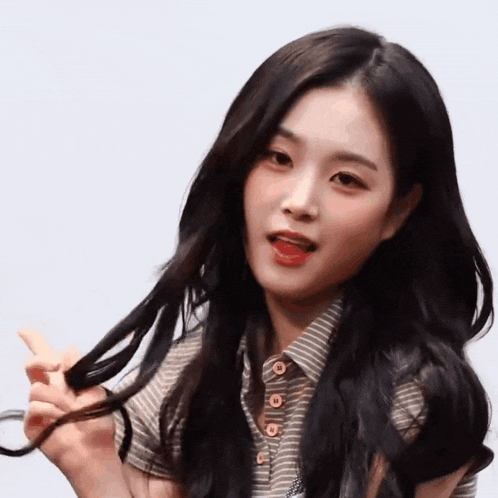 a woman with long black hair is holding her hair in her hands